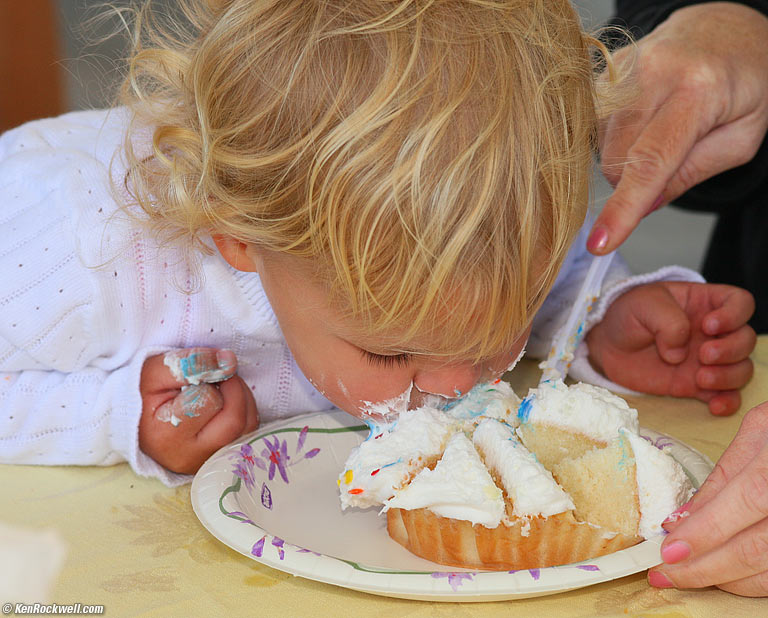 Mom helps Katle cut her cupcake.