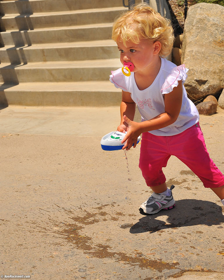 Katie running with a dripping boat at Quail Gardens. 