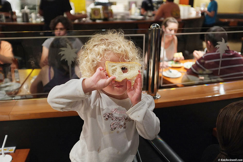 Katie looks through a hole in a peice of bread
