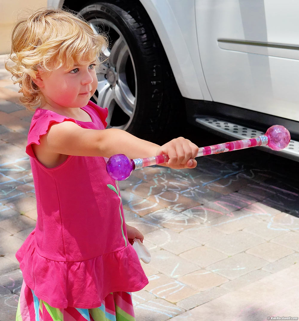 Mom shows Katie how to use the baton