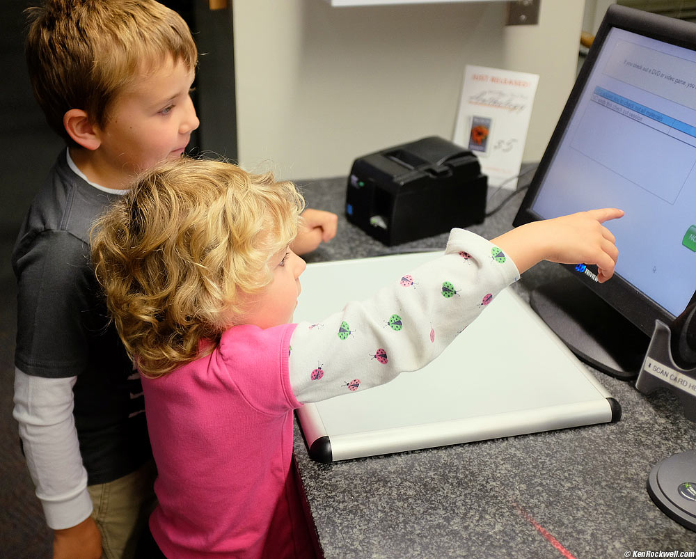 Katie checks-out her books at the library.