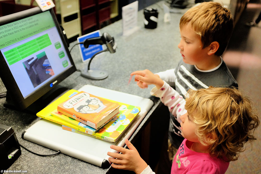 Katie checks-out her books at the library.