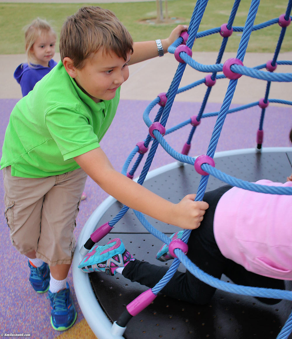 Ryan pushes Katie on the spinny thing.