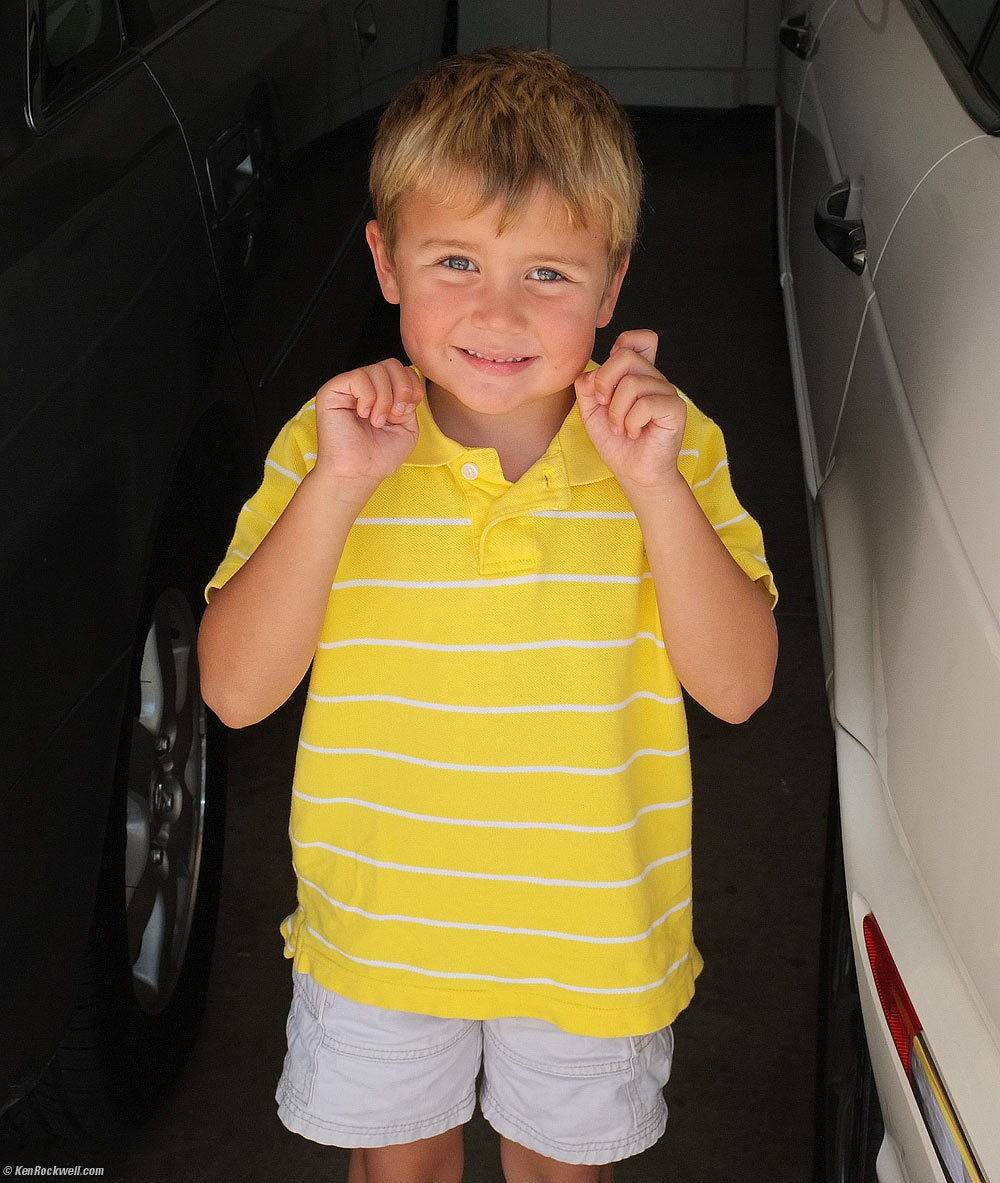 Ryan smiles by the cars.