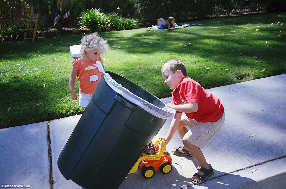 Ryan uses a truck to move the garbage can. 