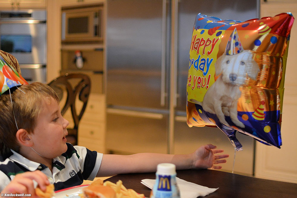 Ryan at the table with Dada's birthday balloon.