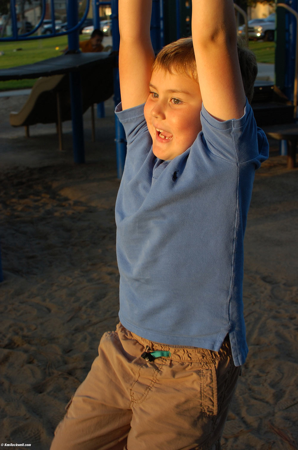 Ryan swings on the gliding handle at the park.