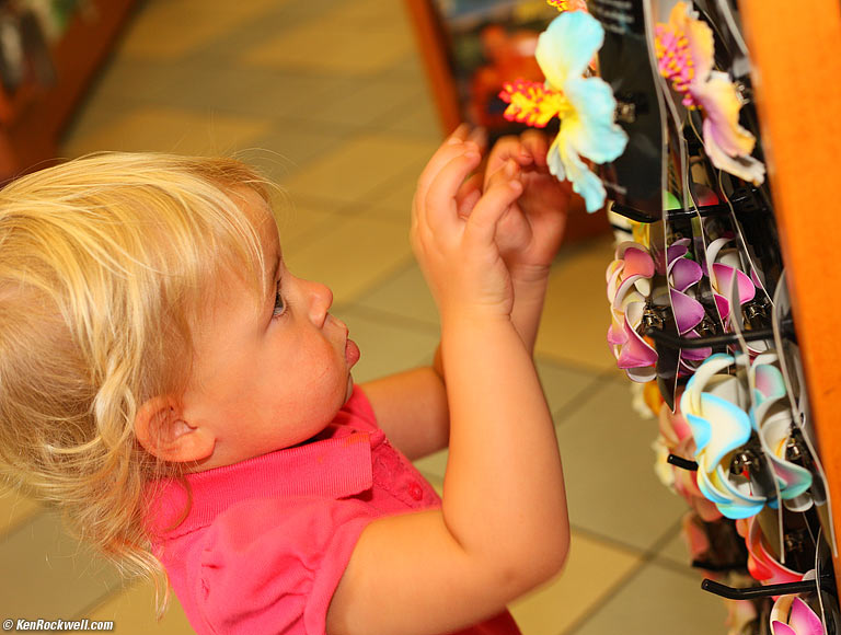 Katie playing with fake flowers, ABC Store, Kihei, Maui. 10:32 AM.