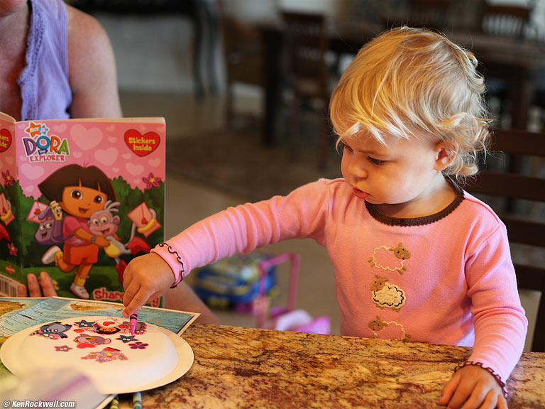 Katie coloring some stickers with Aunt Lisa, Maui. 12:28 PM.