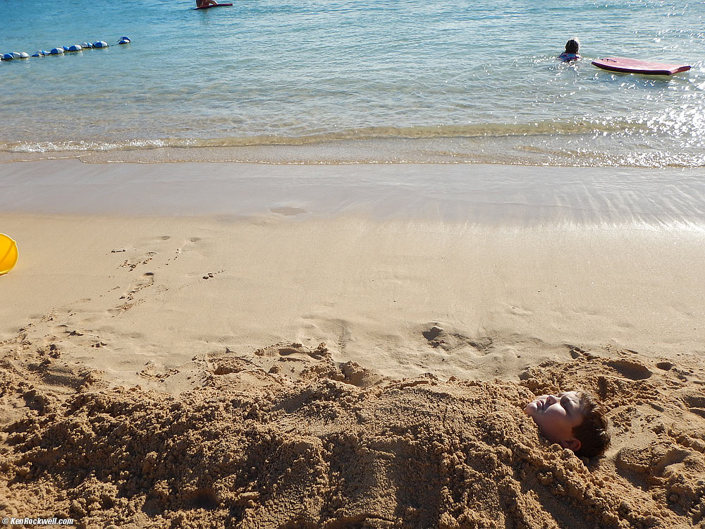 Ryan buried in the sand as Katie boogie boards